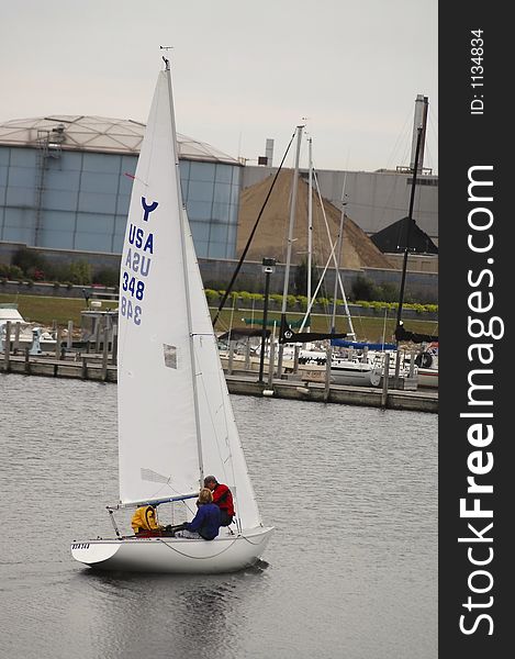 A sailboat sails downriver.