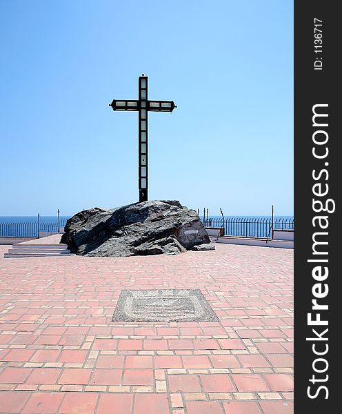 Religious cross set in rocks on a large terrace on a sunny day