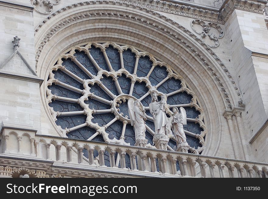 Stained Glass window from the notre dame cathedral in paris with angel statues in fron. Stained Glass window from the notre dame cathedral in paris with angel statues in fron