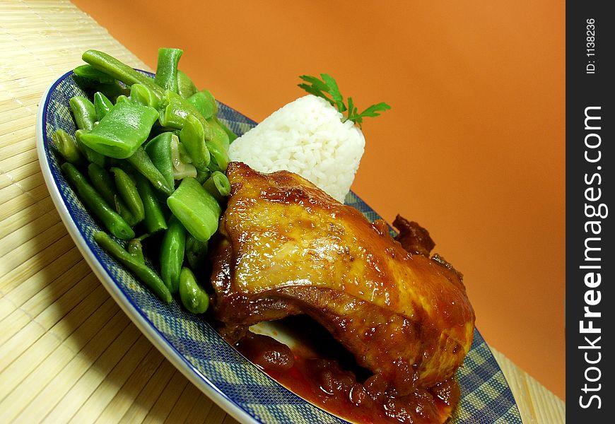 Chicken whit tomato sauce and cooked rice served whit green beans