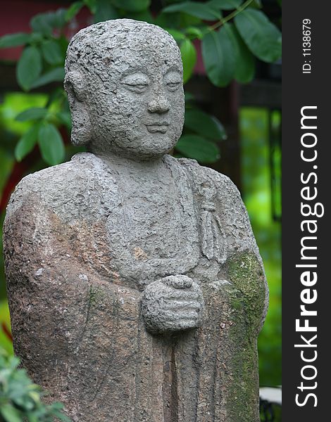 Asian statue on green leaf background