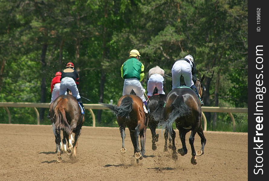 Horses and riders slowing down after the race. Horses and riders slowing down after the race