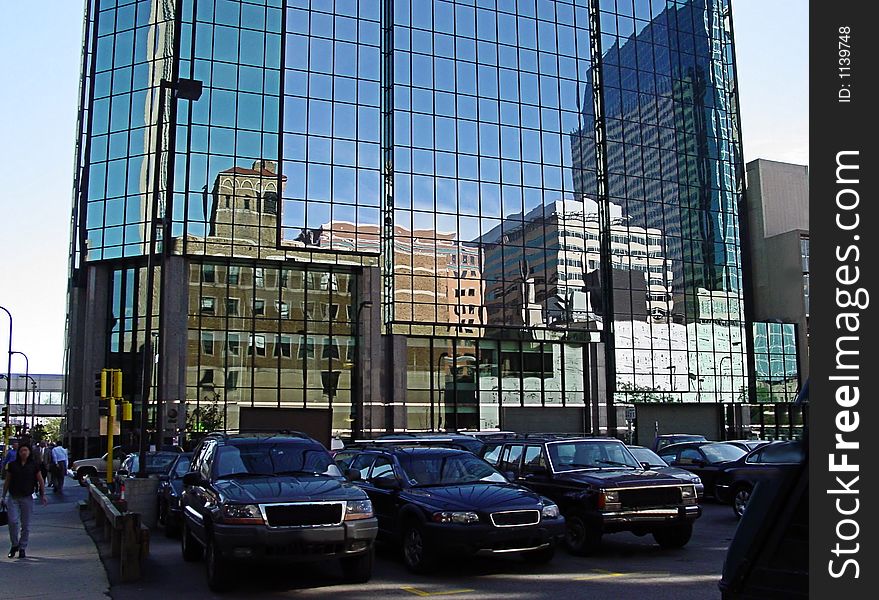 Downtown buildings reflected in glass building at ground level. Downtown buildings reflected in glass building at ground level