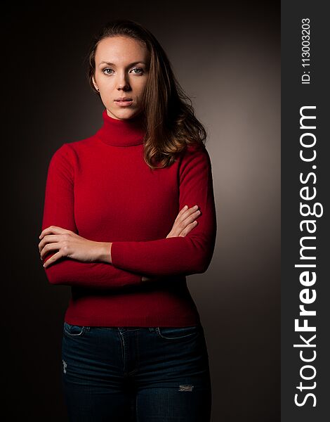 Creaqtive portrait of a beautiful young caucasian happy woman in red wool kneeted sweater