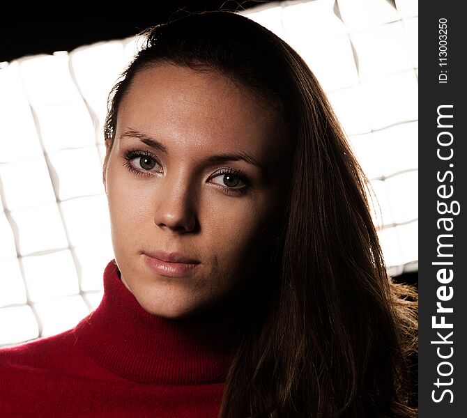 Creaqtive portrait of a beautiful young caucasian happy woman in red wool kneeted sweater .