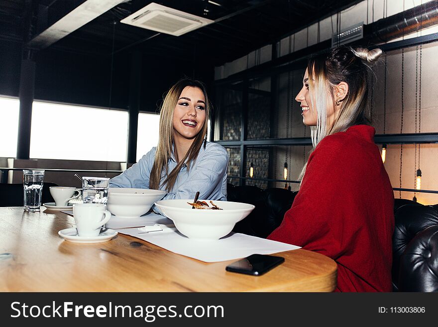 Female friends having lunch together in the modern interior of the restaurant. Female friends having lunch together in the modern interior of the restaurant.