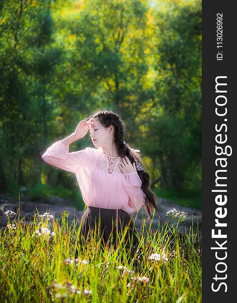 Dreamy girl on a summer sunny day walking in the field of flowers with high grass. Dreamy girl on a summer sunny day walking in the field of flowers with high grass.