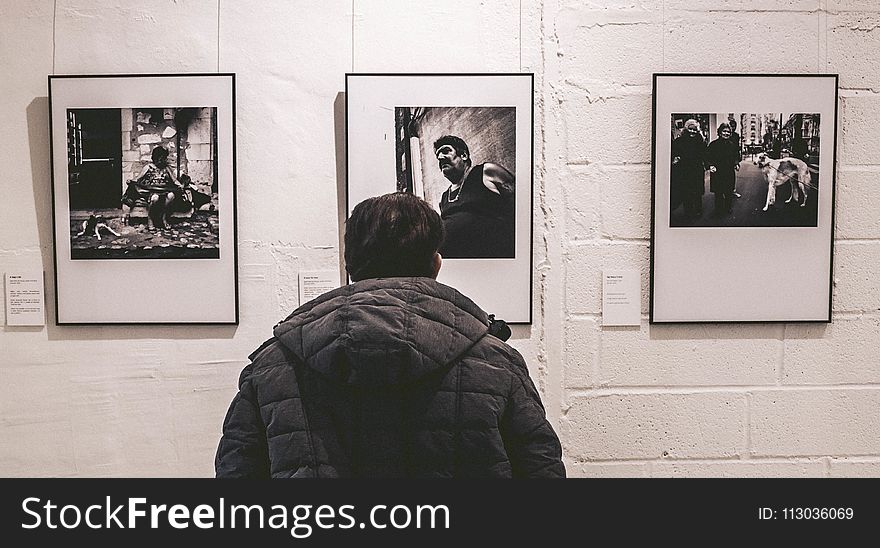 Photo of Person Standing in Front of Three Pictures