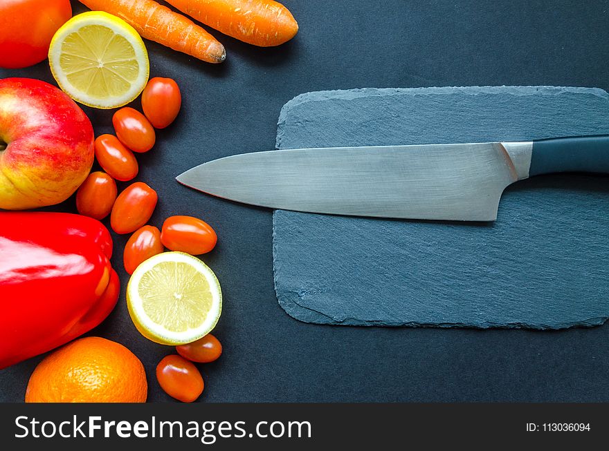 Black Kitchen Knife With Fruits and Vegetable on Table