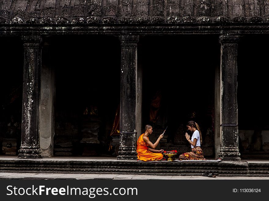Woman Sitting in Front of Monk