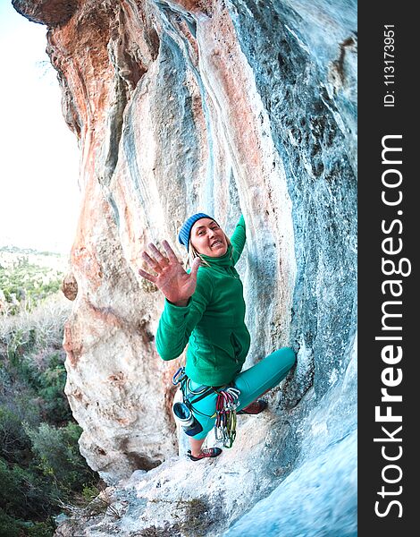 The climber gives five. The woman has overcome the climbing route and is happy with the success. The girl gives five. Gesture of greeting. Fitness in nature.