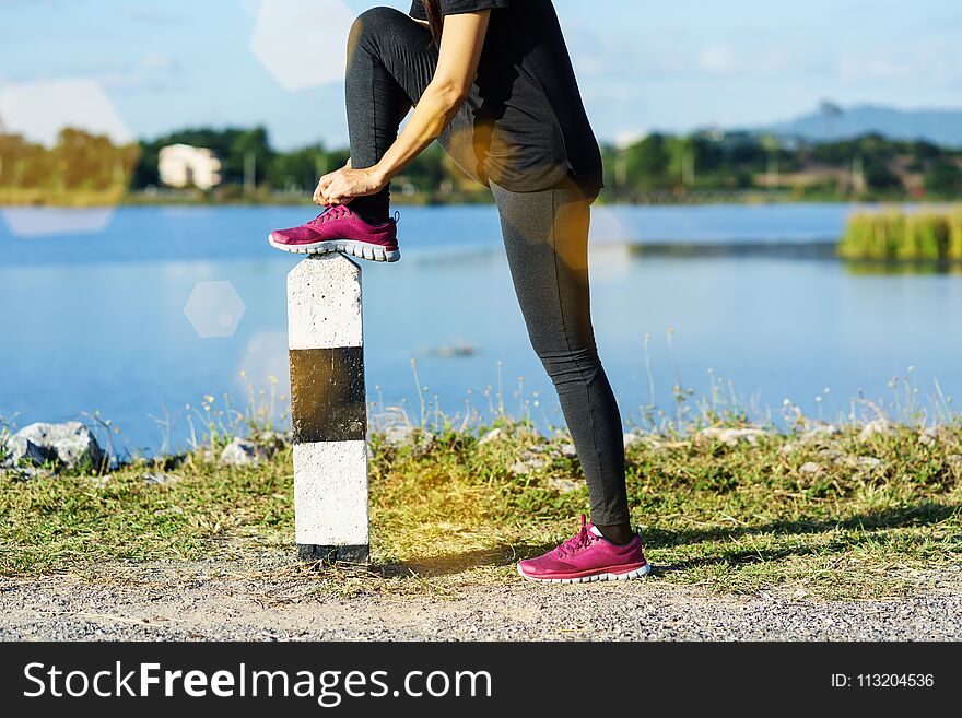 Young Woman Runner Tying Shoelaces