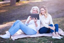 Involved Woman Enjoying Picnic With Aged Mother In The Park Royalty Free Stock Photos