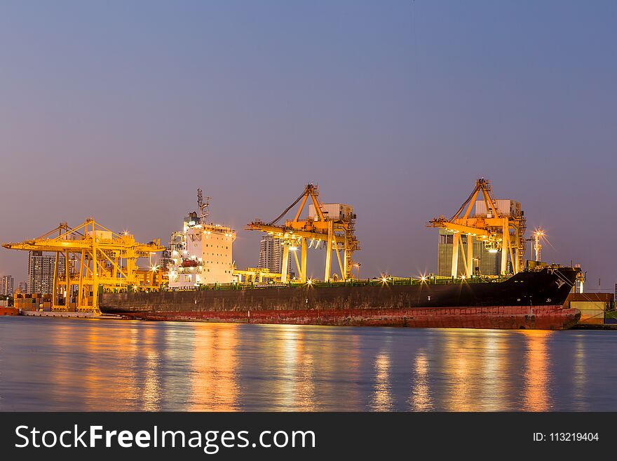 Shipping working loading containers by crane in ship on the night