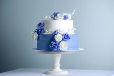 Beautiful Two Tiered White And Blue Wedding Cake Decorated With Flowers Sugar Roses. Concept Of Elegant Holiday Desserts Royalty Free Stock Photography