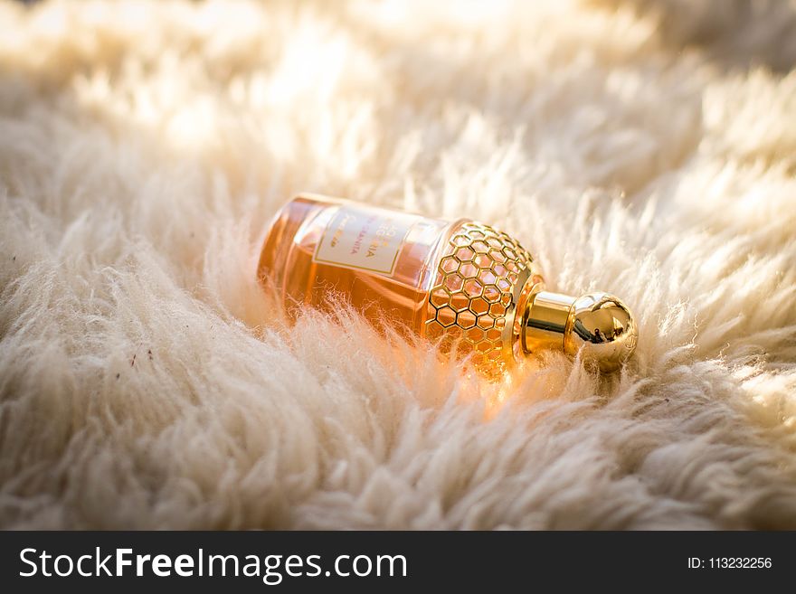 Clear Perfume Bottle On White Fur Textile