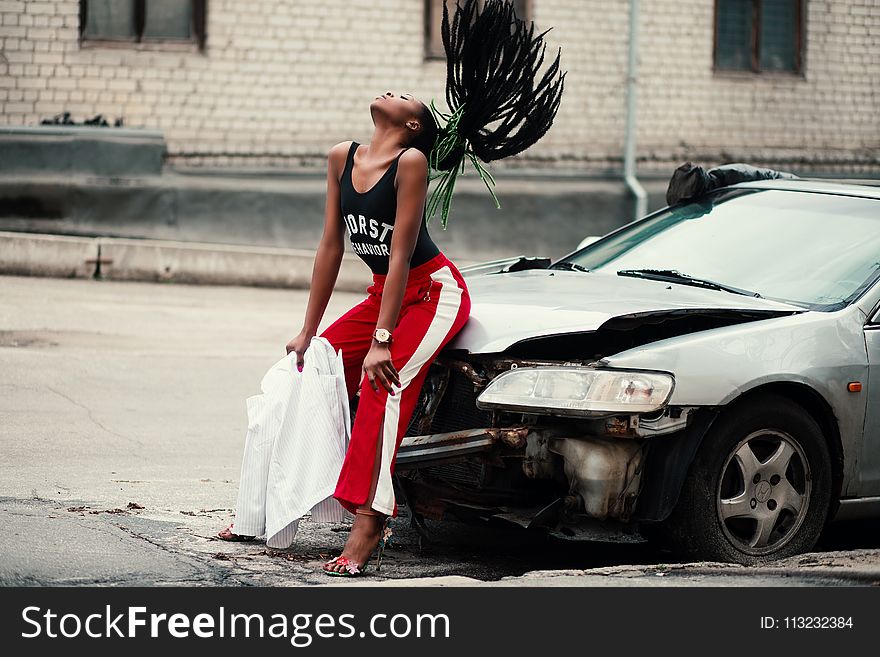 Woman in Black Tank Top Sitting in Front of Car