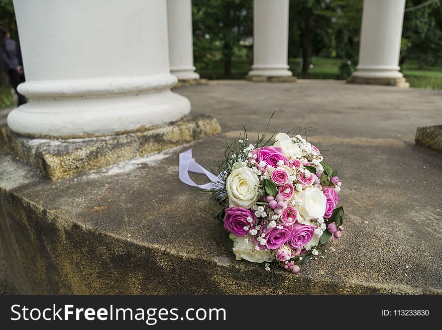 Romantic fresh colorful wedding bouquet of roses with white textile lace and smal cute flowers in aclove with columns. Romantic fresh colorful wedding bouquet of roses with white textile lace and smal cute flowers in aclove with columns