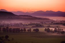 Breathtaking Morning Lansdcape Of Small Bavarian Village Covered In Fog. Scenic View Of Bavarian Alps At Sunrise With Majestic Mou Royalty Free Stock Photo