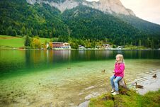 Cute Little Girl Enjoying The View Of Wonderful Green Waters Of Hintersee Lake. Amazing Autumn Landscape Of Bavarian Alps On The A Stock Photography