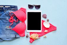 Female Summer Bikini Swimsuit And Accessories On Blue With Tablet And Sunglasses. Stock Images