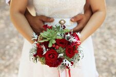 The Bridegroom Embraces The Bride`s Waist, A Wedding Bouquet In Her Hands, In Focus A Bouquet Royalty Free Stock Photography