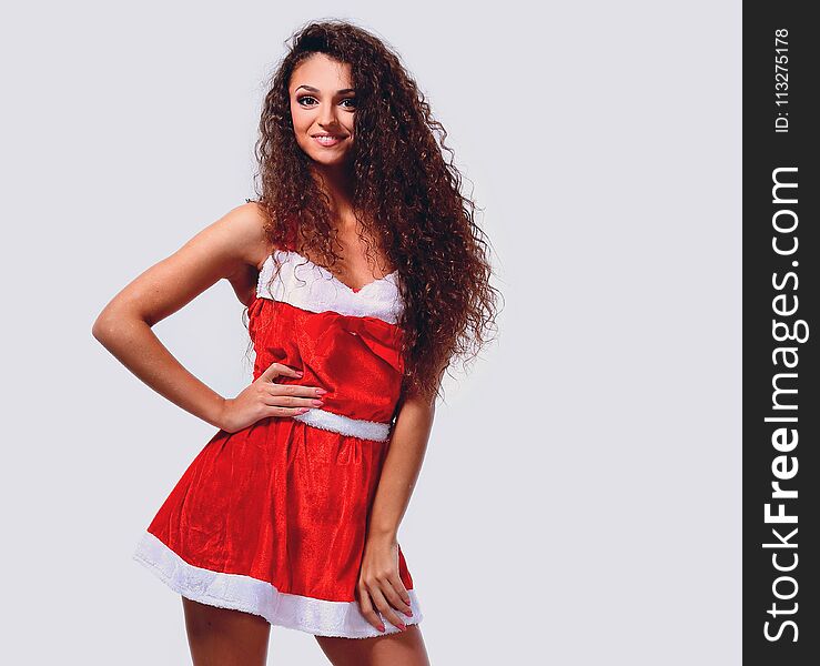 Full-length portrait of sensual young christmas woman posing with short red dress, smiling and looking in camera. Full-length portrait of sensual young christmas woman posing with short red dress, smiling and looking in camera