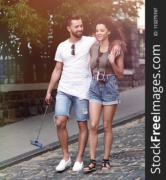 Cheerful young couple walking on urban street