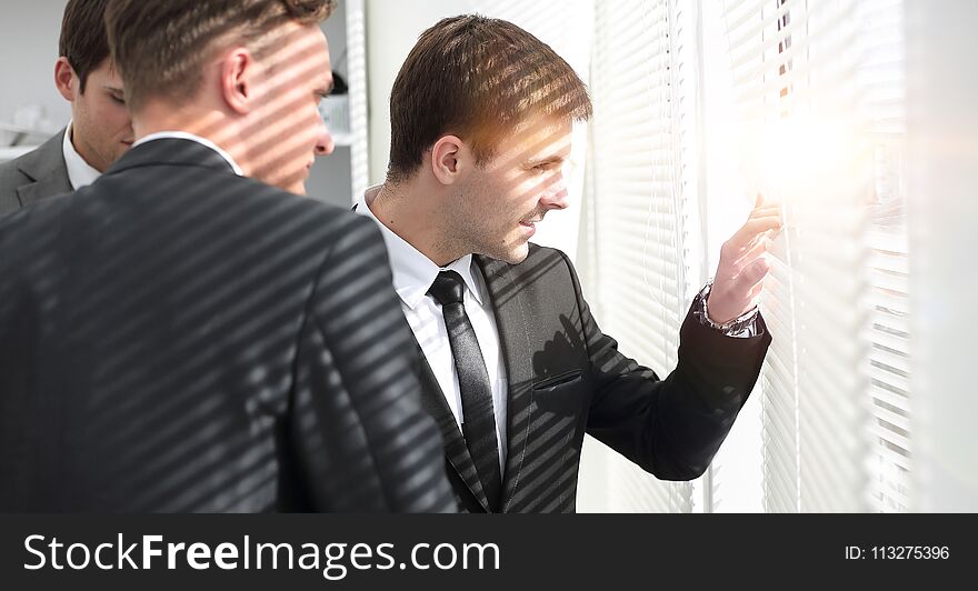 Business partners standing near window in office. Business partners standing near window in office