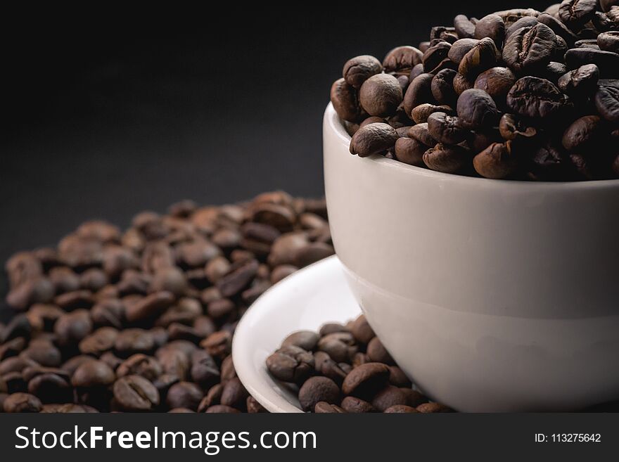 Coffee incup and coffee beans are the background.