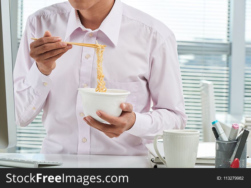 Cropped image of businessman eating instant noodles for lunch