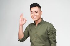 Portrait Of A Cheerful Young Asian Man Showing Okay Gesture Royalty Free Stock Photography