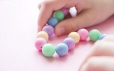 Gently Spring Multi-colored Beads In Children`s Hands Stock Image