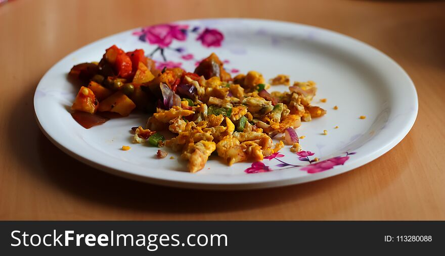 Scrambled egg omlette and mixed vegetable served on a plate. Indian home made dish. side view