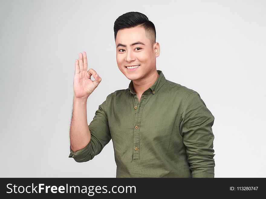 Portrait Of A Cheerful Young Asian Man Showing Okay Gesture