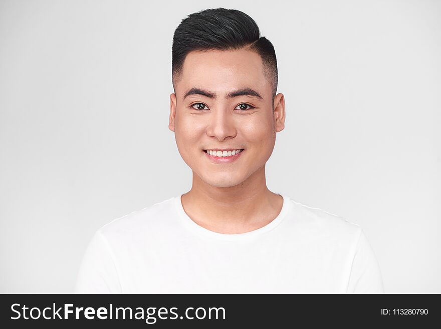 Portrait of handsome young asian man against grey background