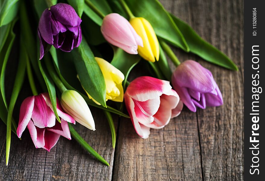 Spring tulips flowers on a white wooden background