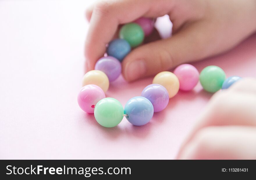 Gently spring multi-colored beads in children`s hands