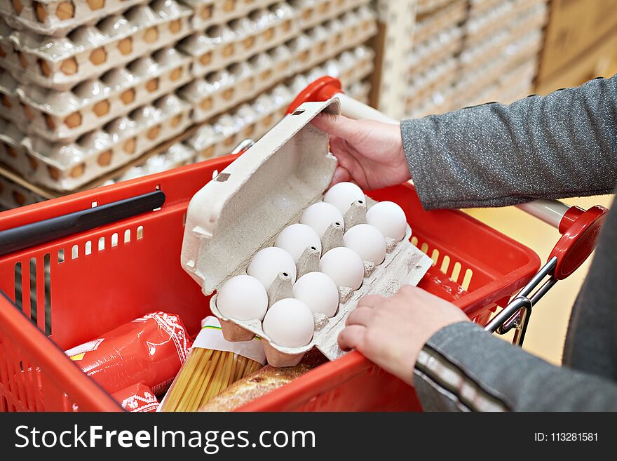 Hands woman with packages of white eggs in the store. Hands woman with packages of white eggs in the store