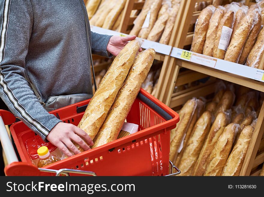 Buyer With Baguettes In Basket At Store