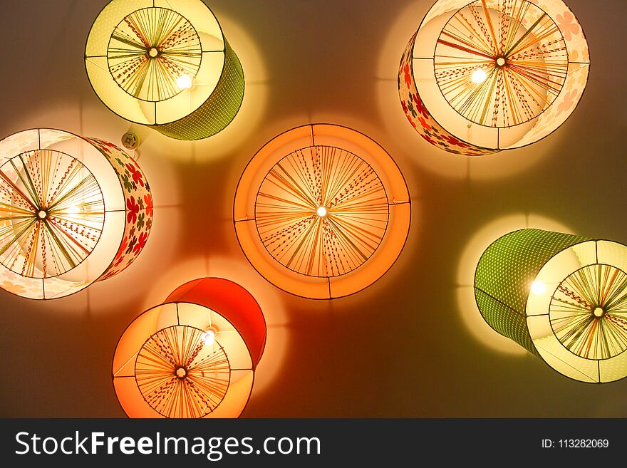 Colored Chandeliers On Ceiling In Nursery.