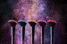 Cosmetic Brushes And Explosion Colorful Powders. Stock Images