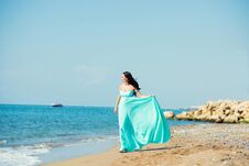 Young Woman In A Blue Dress Is Walking Along The Beach Royalty Free Stock Images