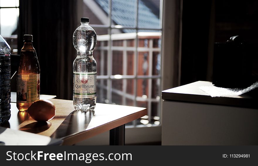 Glass Bottle on Brown Wooden Table