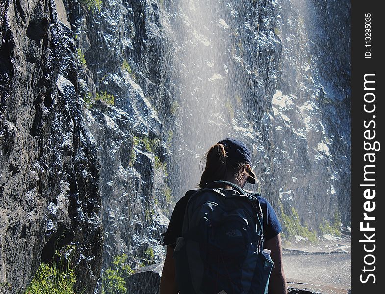 Person Walking Under Waterfalls