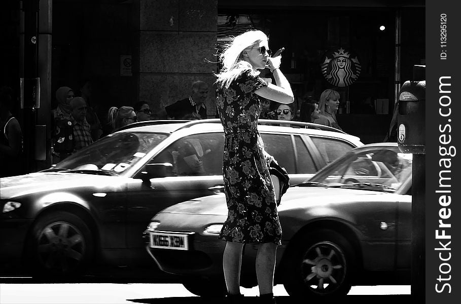 Woman Wearing Floral Short-sleeve Dress Standing Beside Car Grayscale Photo