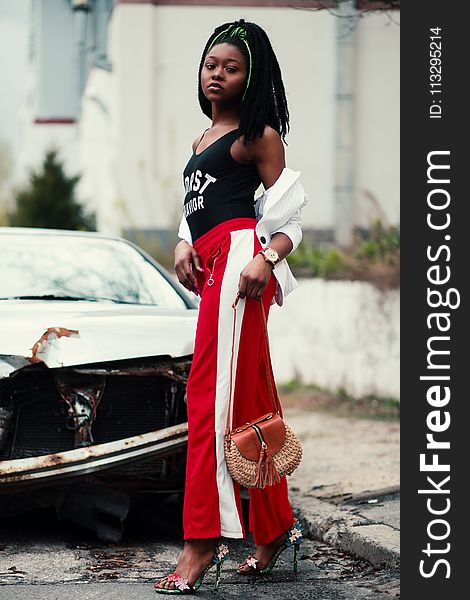 Women&x27;s Black Tank Top And Red Track Pants Walking On Street