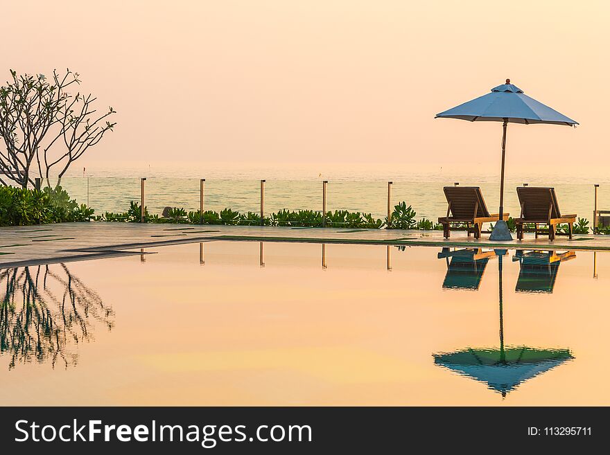 Beautiful Umbrella And Chair Around Swimming Pool In Hotel And R