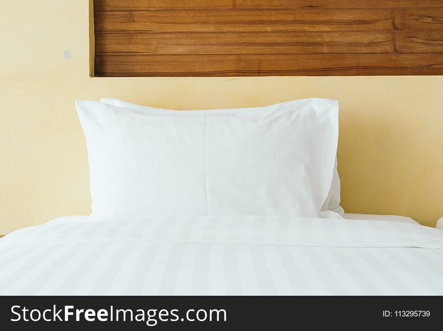 Comfortable white pillow on bed decoration in hotel bedroom interior