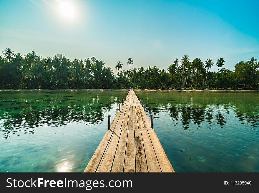 Wood bridge or pier on the beach and sea in paradise island around with coconut palm tree - Holiday Vacation and Travel concept